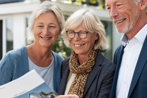Ehepaar bespricht mit Immobilienmakler den Hausverkauf – freundliche Szene vor Einfamilienhaus in Hattingen
